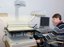 Specialist A. Mazalas is scanning a publication with Bookeye scanner. © D. Mukienė